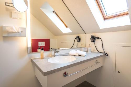 a bathroom with a sink and a mirror at Hotel Restaurant Lamm Hebsack in Remshalden