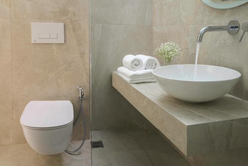a bathroom with a bowl sink and a toilet at Diamond Apartments & Suites in Hersonissos