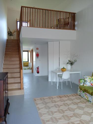 a living room with a staircase and a table at Ocean & Countryside Apartments in Encarnação