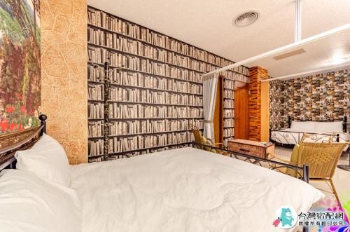 a bedroom with a bed and a wall of books at 蘭貳 宜蘭包棟民宿 in Yilan City
