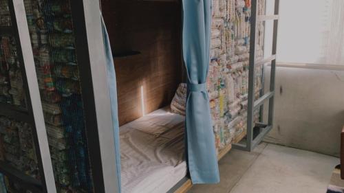 a small bed in a room with a wall at Amouter HC in Hengchun