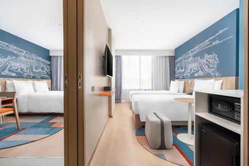 a hotel room with two beds and a table at Holiday Inn Express Rayong in Rayong