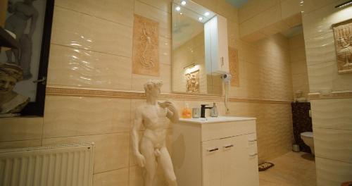 Kamesznica的住宿－4 PORY ROKU POKOJE GOŚCINNE，站在浴室里的男人的雕像