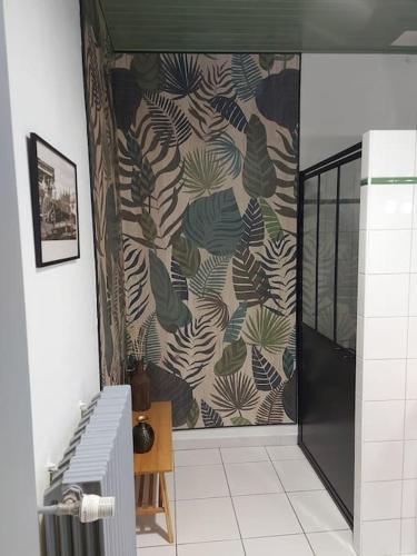 La salle de bains est pourvue d'une fresque murale représentant des feuilles. dans l'établissement La Commanderie Grand Gite 10kms 