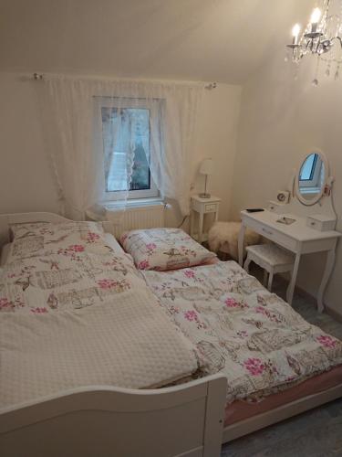 a bedroom with a bed and a desk and a mirror at Ferienhaus Aschersleben in Aschersleben
