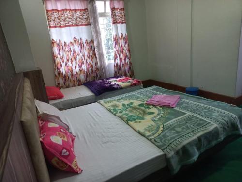 a small room with two beds and a window at Mangan Stone Pebbles Lodge in Mangan