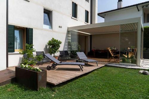 a backyard with a deck with chairs and a table at Bed and Breakfast Canalgrande in Mira