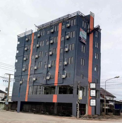 ein großes graues Gebäude mit einem Schild davor in der Unterkunft ME. Hotel in Louang Namtha