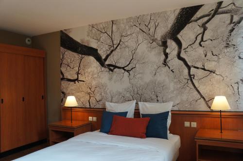 a bedroom with a bed with a painting on the wall at Escale Hotel in Brussels