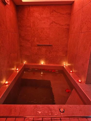 a bath tub with lights in a red room at LUXUITE Spa con Piscina o Jacuzzi in Alberobello