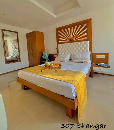 a bedroom with a large bed with a wooden headboard at Beach Paradise Miramar Goa in Panaji