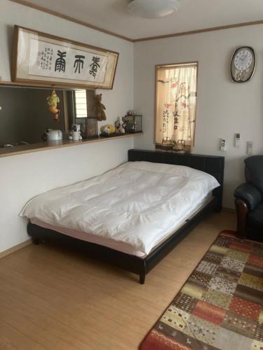 a bedroom with a bed and a chair and a window at 澄の宿 琵琶湖畔松の浦水泳场 jr志賀车站 滑雪场登山巴士站全部徒步0分钟 免费停车位3台 in Otsu