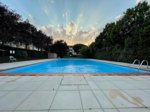 une grande piscine bleue dans une cour dans l'établissement Manoir by Yumē, à Toulouse