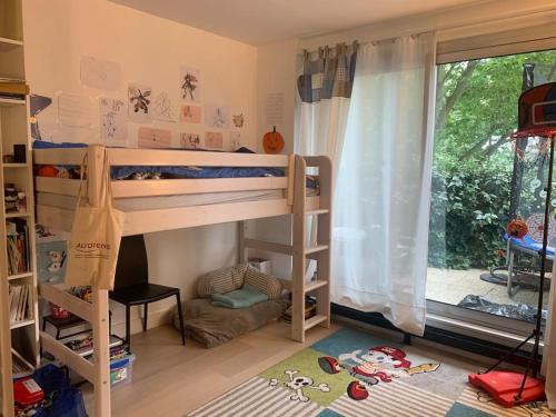 Pokój z 2 łóżkami piętrowymi i oknem w obiekcie Appartement familial tt confort JO paris w mieście Saint-Cloud