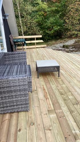 a patio with two chairs and a bench on a deck at Stuga Lotte in Billdal