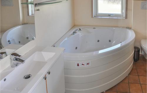 ein weißes Badezimmer mit einer Badewanne und einem Waschbecken in der Unterkunft Pet Friendly Home In Nordborg With Sauna in Nordborg