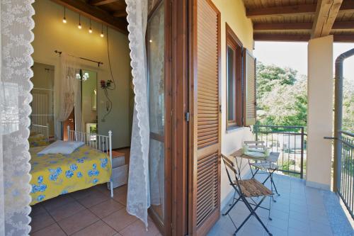 a bedroom with a bed and a balcony with a table at Residenz La Fonte Studios in Pino Lago Maggiore