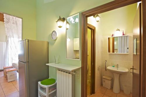 a small bathroom with a sink and a refrigerator at Residenz La Fonte Studios in Pino Lago Maggiore