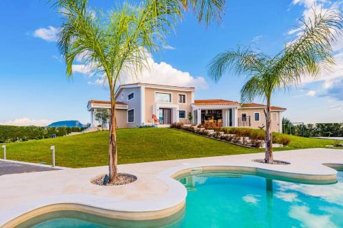 uma casa com duas palmeiras em frente a uma piscina em Villa Shangri-La em Sarakinádhon