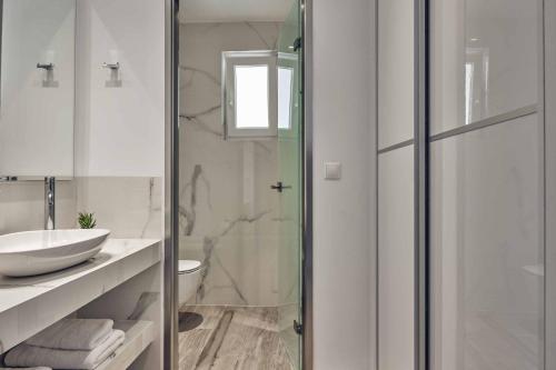 a bathroom with a glass shower and a sink at Sun Villa View in Lithakia