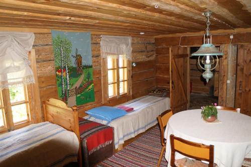 a bedroom with two beds and a table in a room at Anni Tourism Farm in Tammese