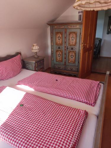 a bed with a red and white checkered blanket at Berggasthaus & Pension Schöne Aussicht in Klingenthal