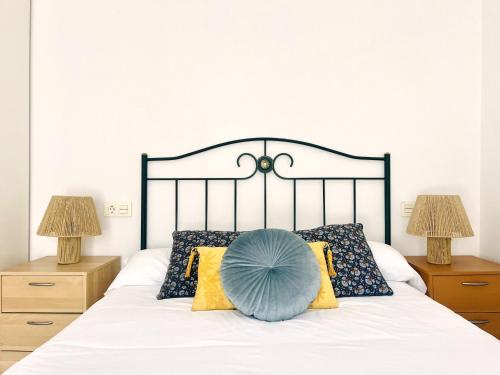 a bed with a blue pillow on top of it at Housingleón Cardiles I y II in León