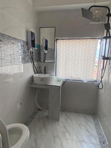 biała łazienka z umywalką i toaletą w obiekcie ME. Hotel w mieście Louang Namtha