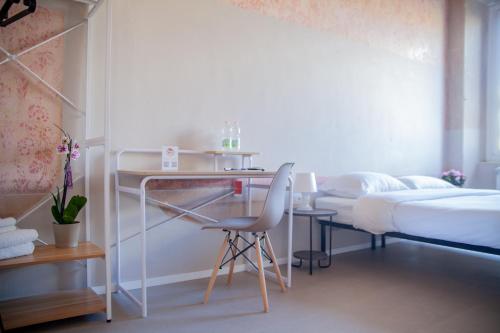1 dormitorio con escritorio, 1 cama y 1 silla en Aretium, en Arezzo