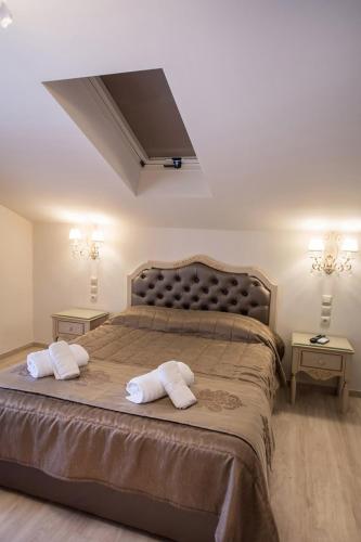 a bedroom with a large bed with two pillows on it at SUITES PIROFANI in Lefkada