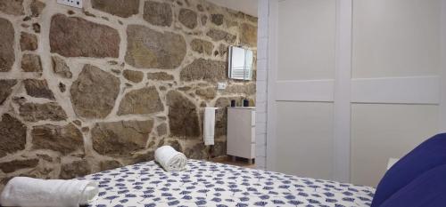 um quarto com uma parede de pedra e uma cama em Casa Gil - AL em Valença