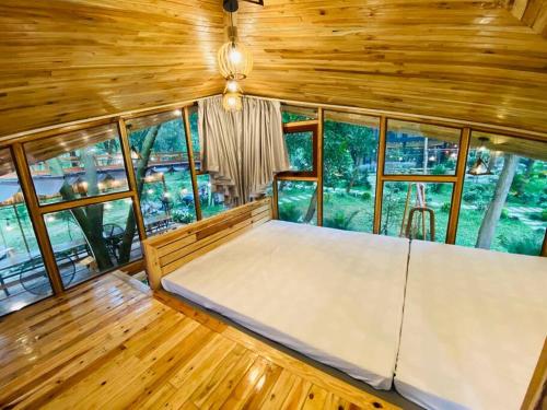 a large bed in a room with windows at Căn Bali (Moon Villa Sóc Sơn) in Hanoi