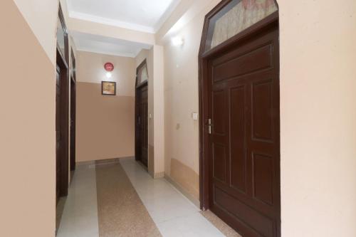 a hallway with a brown door in a room at Kavi Home Stay in Mussoorie