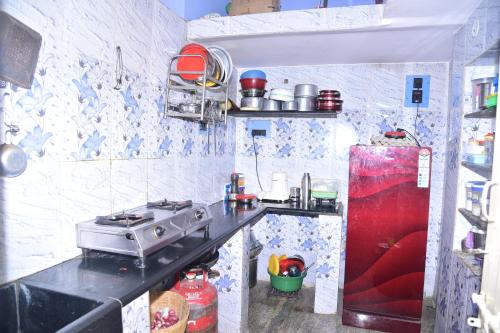 a small kitchen with a stove and a refrigerator at Private 2BHK HOMESTAY Mysore in Mysore