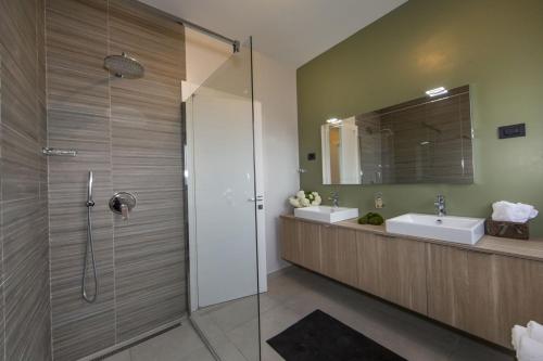 a bathroom with two sinks and a glass shower at Villa Verde in Vošteni