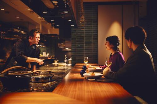 un grupo de personas sentadas en una mesa en un restaurante en Hotel Indigo Tokyo Shibuya en Tokio