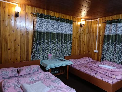 a room with two beds and a table in it at Mount View Homestay Sittong in Mangpu