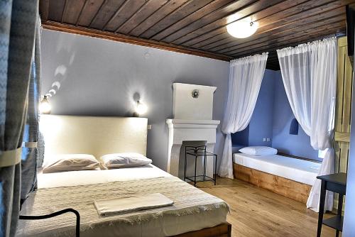 a bedroom with a bed and a tub in it at Melina Hotel - Heritage in Poligiros