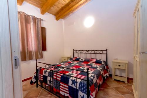 a bedroom with a bed with a quilt on it at Acquapark Isola Rossa Costa Rossa in Isola Rossa