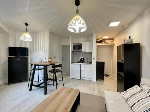 Il comprend un salon et une cuisine avec une table et un canapé. dans l'établissement Catalans by Yumē, à Toulouse