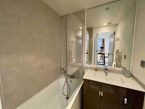 une salle de bain avec une baignoire, un lavabo et un miroir dans l'établissement Catalans by Yumē, à Toulouse