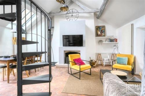 - un salon avec deux chaises jaunes et une cheminée dans l'établissement L'appartement de Diane - Terrasse et Centre, à Fontainebleau