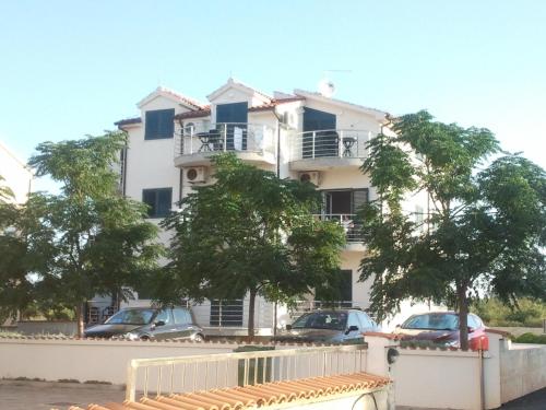 a white building with cars parked in front of it at Villa Srima in Vodice