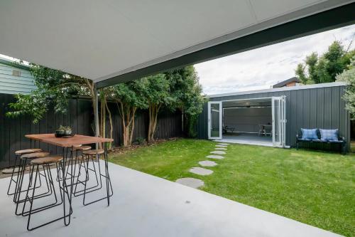 un patio con una mesa y sillas en el césped en Inner city home West Footscray close to everything en Seddon