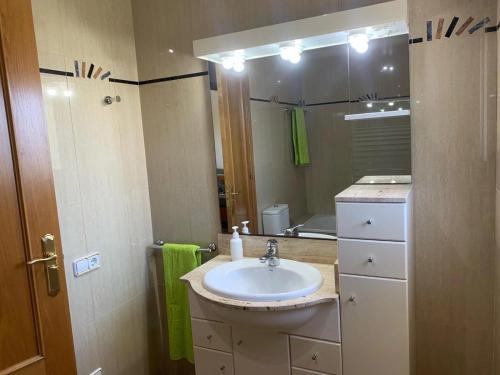 uma casa de banho com um lavatório e um espelho em Villa Victoria em L'Ampolla
