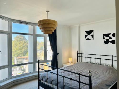 um quarto com uma cama e uma grande janela em Spacious and Bright Apartment em Londres