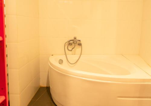 a white bath tub in a bathroom with a toilet at Ivory Falls Villa in Di Linh