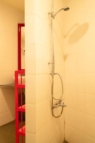 a shower in a bathroom with a red shelf at Ivory Falls Villa in Di Linh