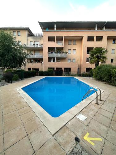 une grande piscine devant un immeuble dans l'établissement Airbus by Yumē, à Toulouse