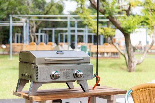 a grill sitting on a picnic table in a park at glampark FREE AND EASY CAMP RESORT　三重県 in Komono